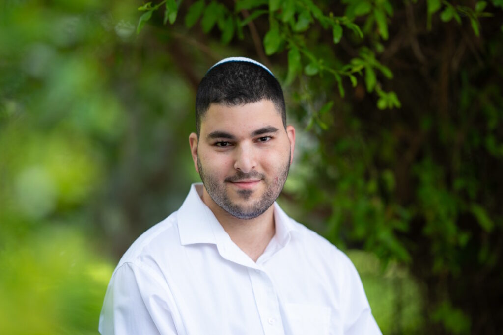 גבר צעיר עם כיפה וחולצה לבנה, פורטרט על רקע ירוק