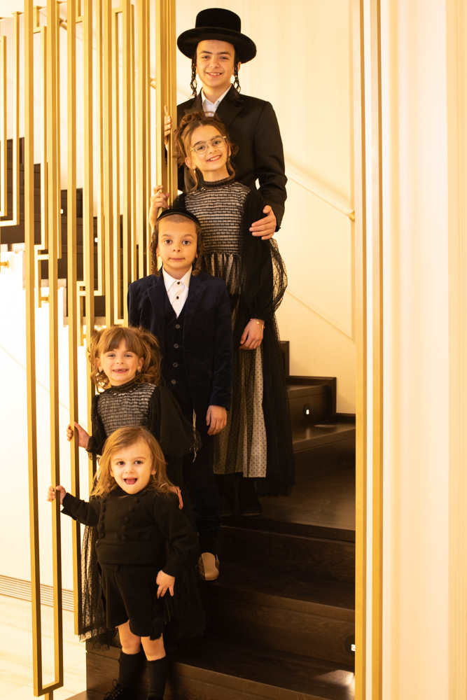 הילדים בצילום משפחתי על גרם המדרגות בבית המשפחות