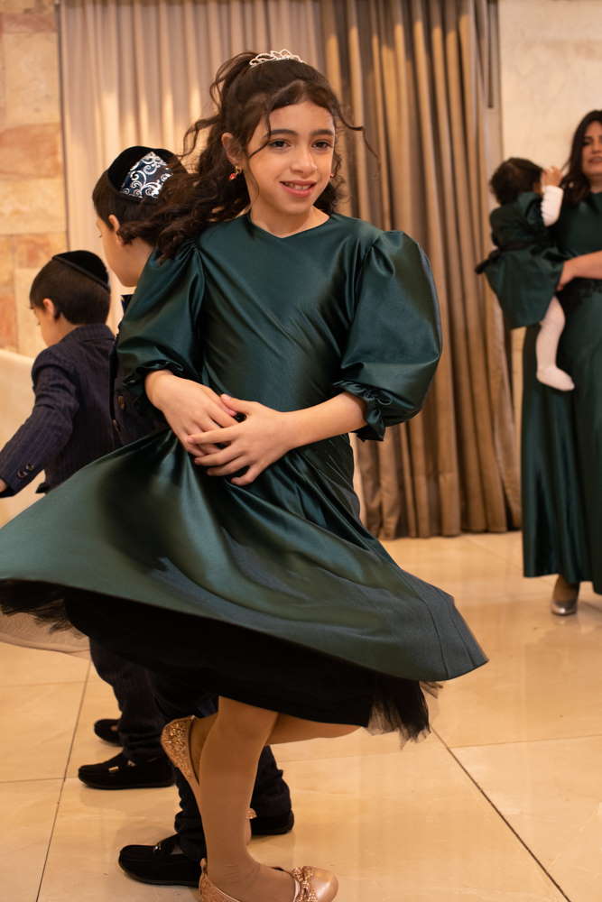 ילדה רוקדת בשמלה ירוקה באולם