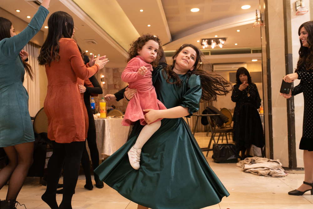 ילדה אוחזת את אחותה הקטנה בריקודים