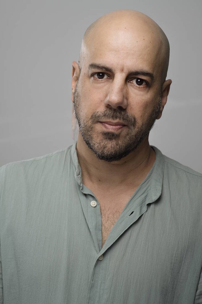 פורטרט אמנותי של שחקן בחולצה מכופתרת רכה, במבט ישיר וכנה. הקומפוזיציה הפשוטה מאפשרת לאישיותו הייחודית לבלוט בתמונה.