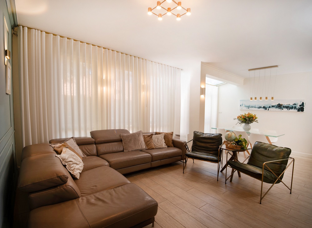 סלון עם ספה חומה ווילונות לבנים