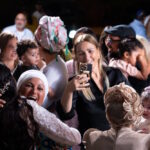 כלה חב״דית מחובקת עם נשים ואורחים בחתונה