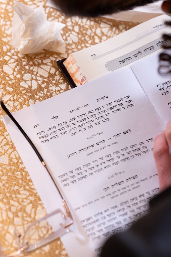חתן חסידי בתפילה מתוך סידור לפני החופה, צילום חתונה חסידית אותנטי