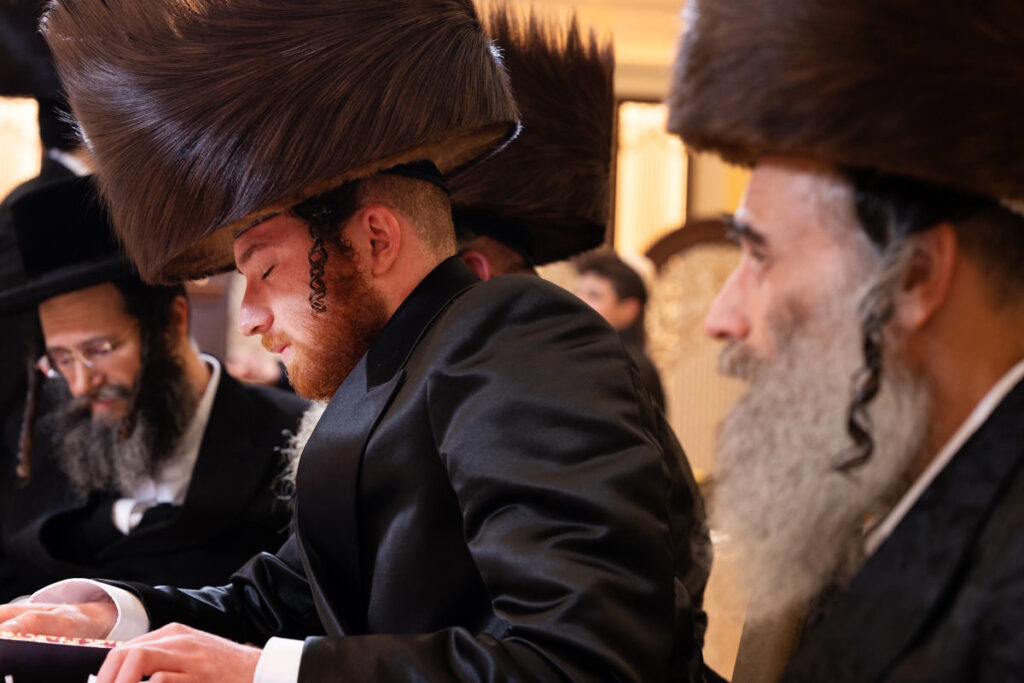 אורחים בחתונה חסידית בבית שמש חובשים שטריימל ושקועים בתפילה.
