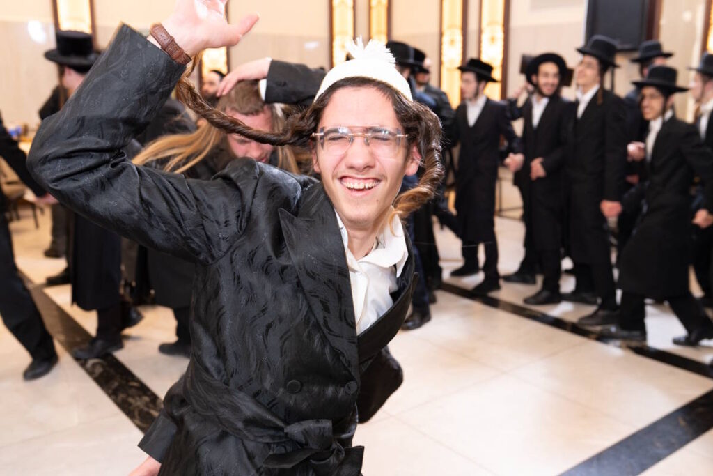 צעיר חסידי רוקד בהתלהבות ושמחה, צילום אירועים במגזר החרדי.