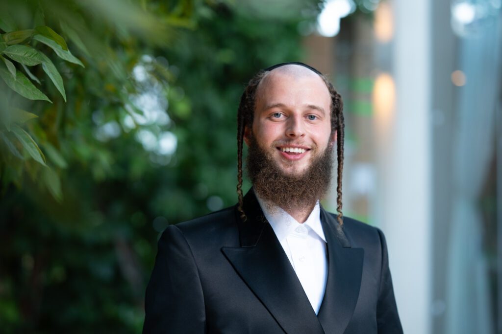 פורטרט חתן ברסלב מחייך בחליפה מסורתית ופאות – צלם לחתונה חרדית