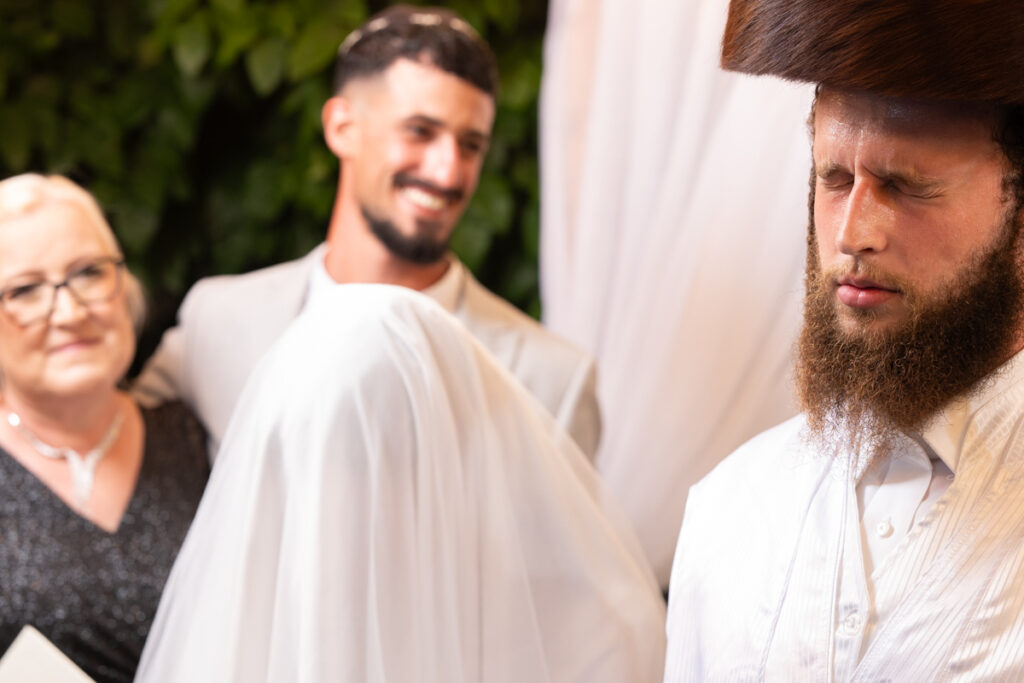 צילום תקריב חתן חסידי מתפלל בדבקות בחופה – צילום חתונה ברסלב