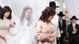 הכלה מלווה באימהות מקיפה את החתן בחופה