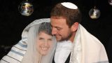 חתן וכלה מתעטפים בטלית בחופה